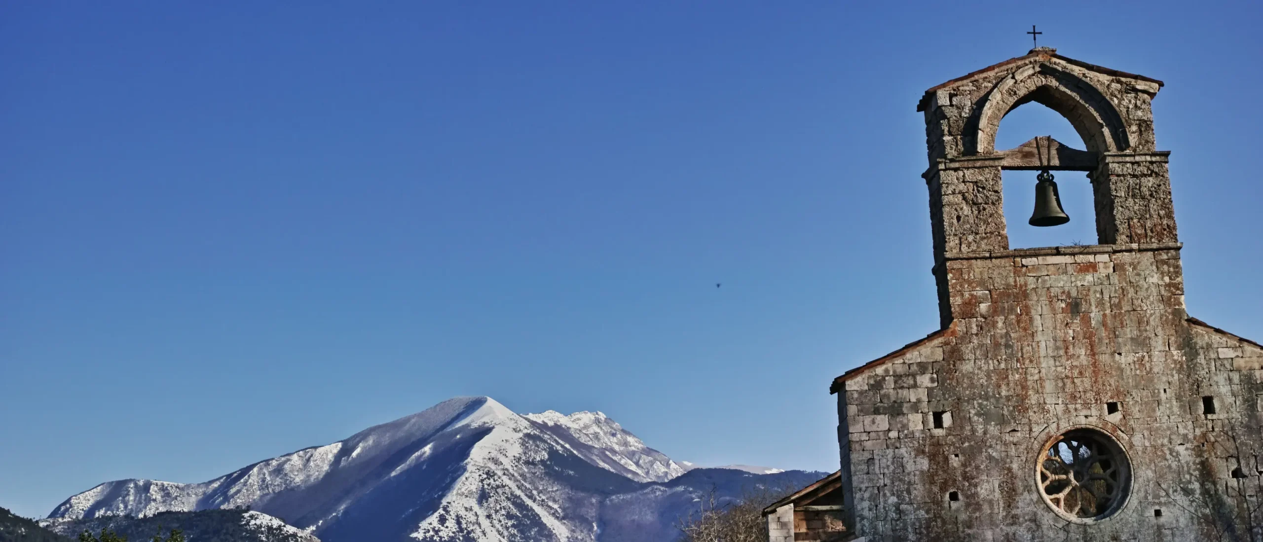 Campanile di una chiesa storica con cielo blu.